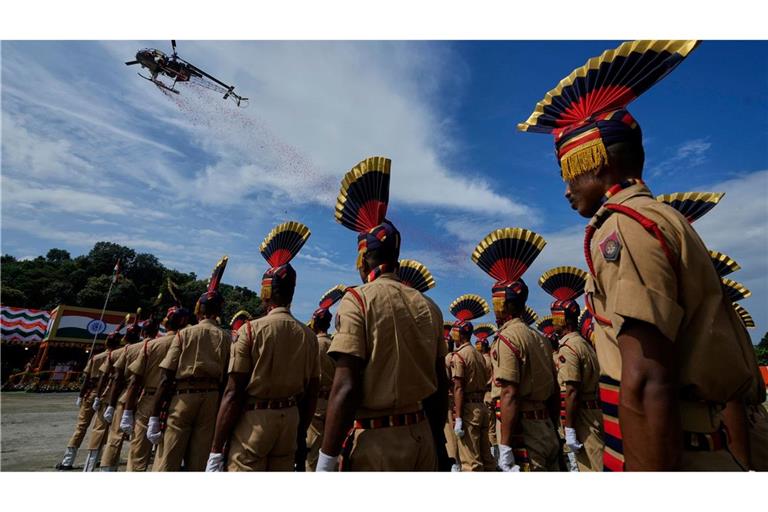 Ein Hubschrauber der indischen Luftwaffe wirft in Guwahati Blüten ab, während Angehörige der Polizei von Assam an einer Parade der Feierlichkeiten zum Unabhängigkeitstag teilnehmen. Der Unabhängigkeitstag Indiens wird jährlich am 15. August begangen.