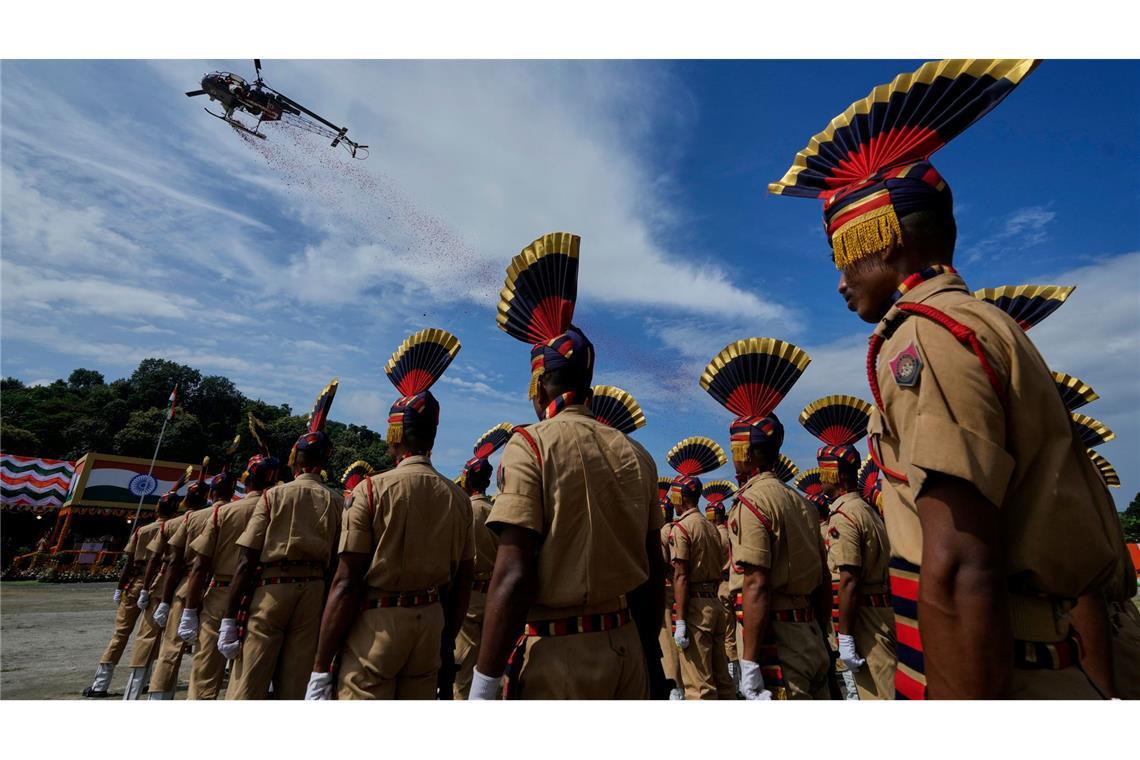 Ein Hubschrauber der indischen Luftwaffe wirft in Guwahati Blüten ab, während Angehörige der Polizei von Assam an einer Parade der Feierlichkeiten zum Unabhängigkeitstag teilnehmen. Der Unabhängigkeitstag Indiens wird jährlich am 15. August begangen.