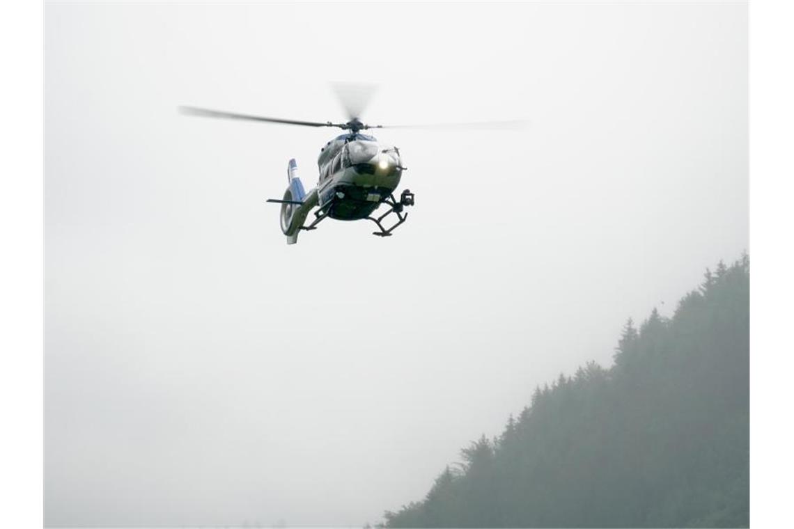 Ein Hubschrauber der Polizei fliegt bei Oppenau. Foto: Benedikt Spether/dpa
