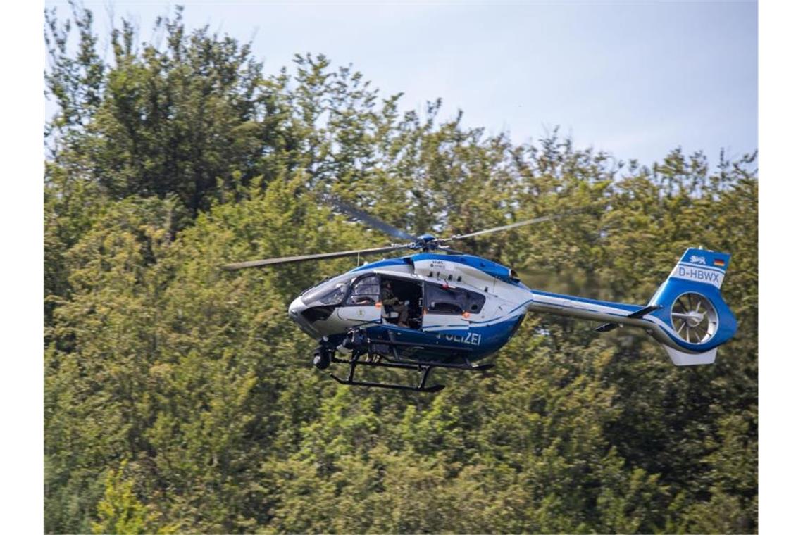 Ein Hubschrauber der Polizei fliegt nahe der Gemeinde Oppenau über den Wald. Foto: Philipp von Ditfurth/dpa