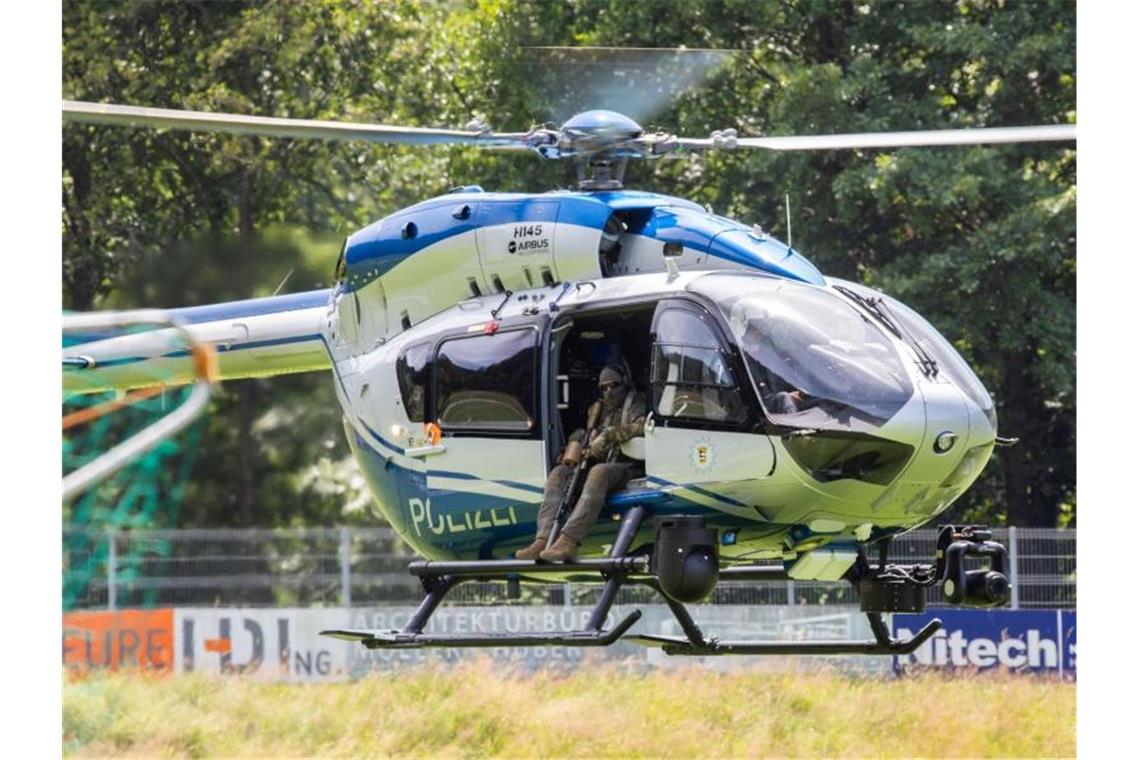 Ein Hubschrauber der Polizei landet nahe der Gemeinde Oppenau auf einem Sportplatz, der der Polizei als Sammelpunkt dient. Foto: Philipp von Ditfurth/dpa