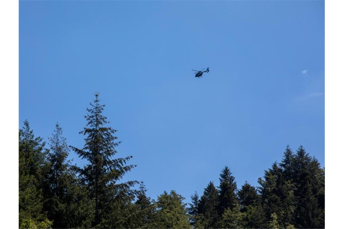 Ein Hubschrauber der Polizei schwebt nahe Oppenau in der Luft. Ein mit Pfeilen und Bogen bewaffneter Mann hat in dem Ort im Schwarzwald Polizisten bedroht und ihnen die Waffen abgenommen. Foto: Philipp von Ditfurth/dpa