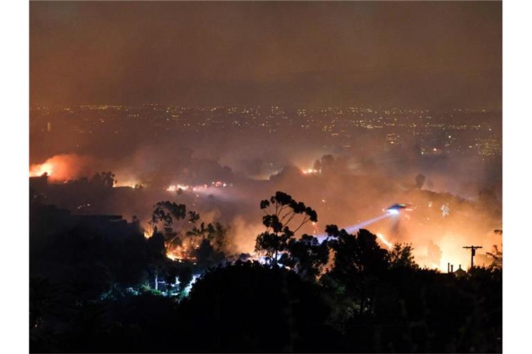 Ein Hubschrauber fliegt über einem Wohngebiet, das vom sogenannten „Getty“-Feuer betroffen ist. Foto: David Crane/Orange County Register via ZUMA/dpa