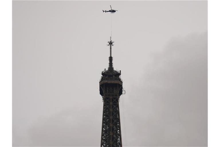 Ein Hubschrauber installiert die neue Antenne auf der Spitze des Eiffelturms. Foto: Francois Mori/AP/dpa
