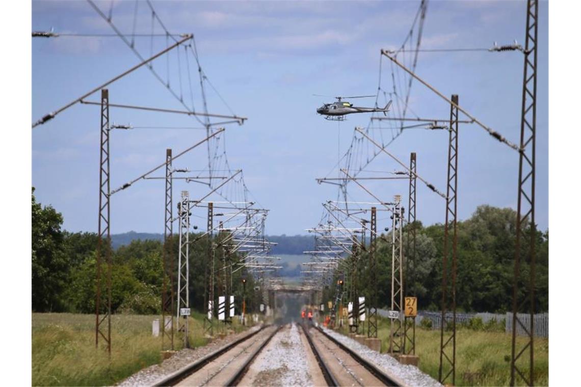 Ein Hubschrauber transportiert über der am Pfingstwochenende 2019 gesperrten Bahnstrecke Augsburg-Donauwörth einen Signalmasten der Bahn. Foto: Karl-Josef Hildenbrand