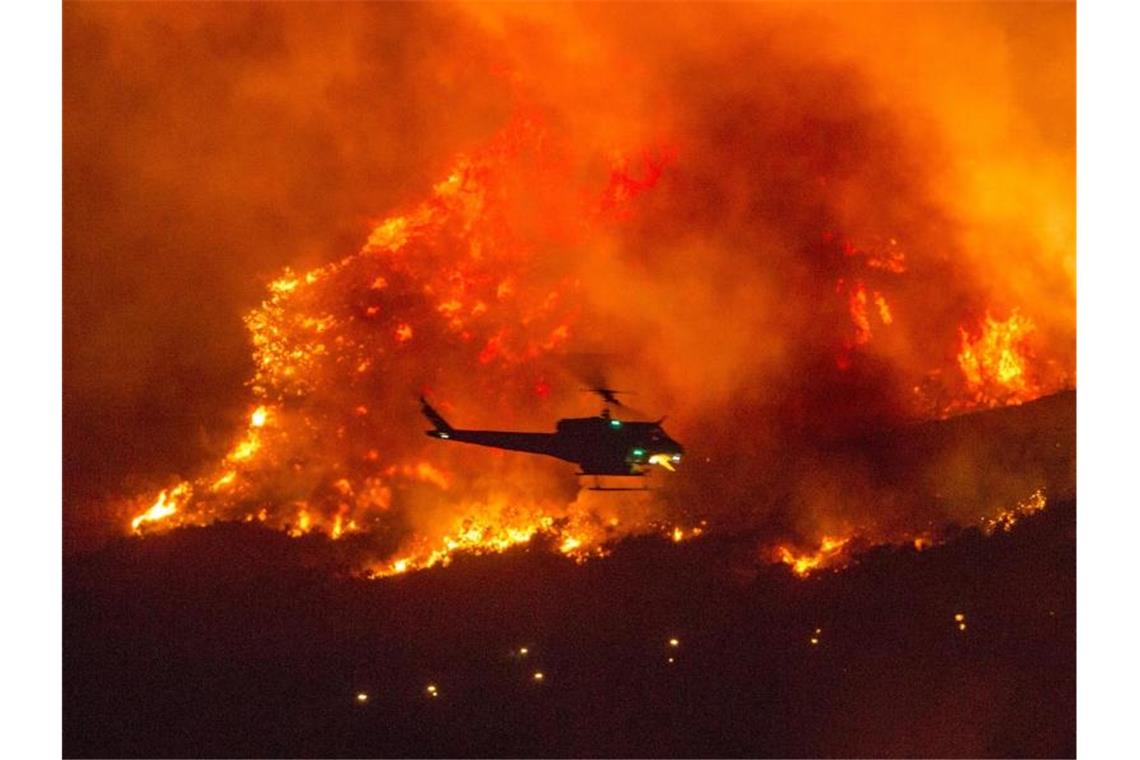 Mehr als 200 Camper in Kalifornien aus Feuerzone gerettet Ein Hubschrauber versucht, die sich ausbreitenden Buschfeuer in Kalifornien zu löschen. Foto: Ringo H.W. Chiu/FR170512 AP/dpa