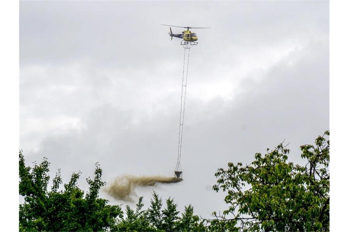Ein Hubschrauber wirft im Bezirk Schurwald Kalk aus einem Behälter auf Bäume ab. Foto: Sven Kohls/SDMG/dpa/Archiv