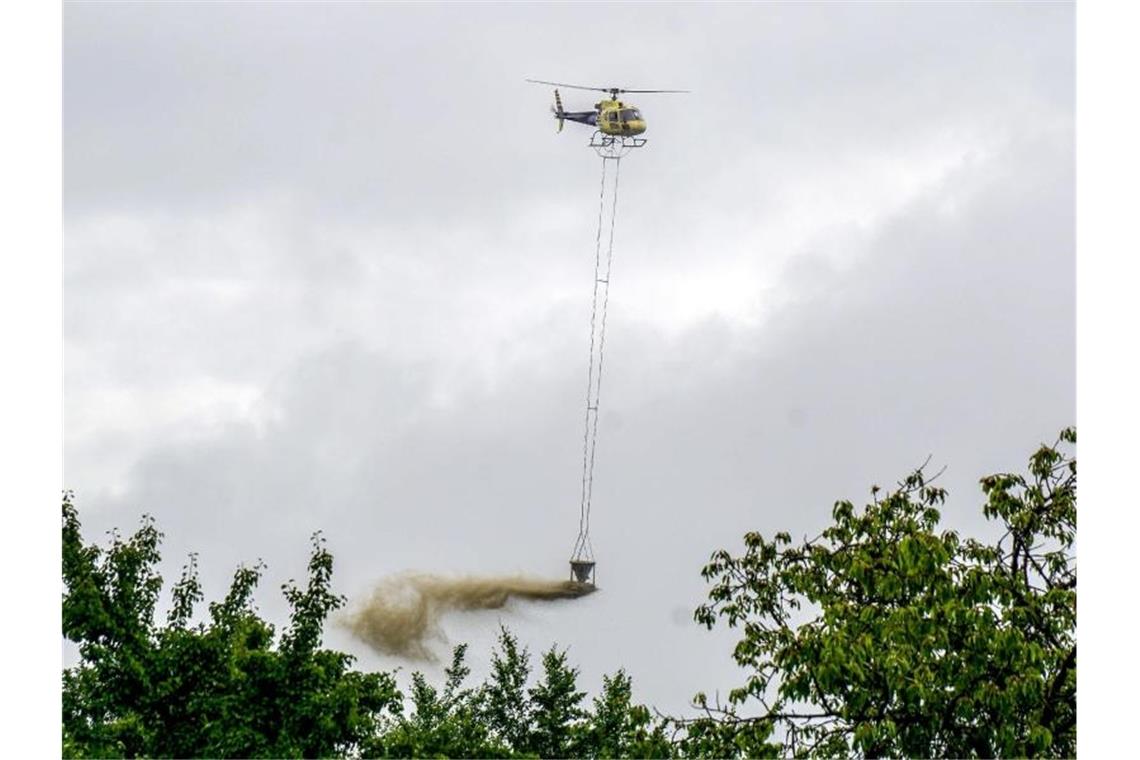 Land setzt Kalkungen der Wälder gegen Bodenversauerung fort Ein Hubschrauber wirft im Bezirk Schurwald Kalk aus einem Behälter auf Bäume ab. Foto: Sven Kohls/SDMG/dpa/Archiv