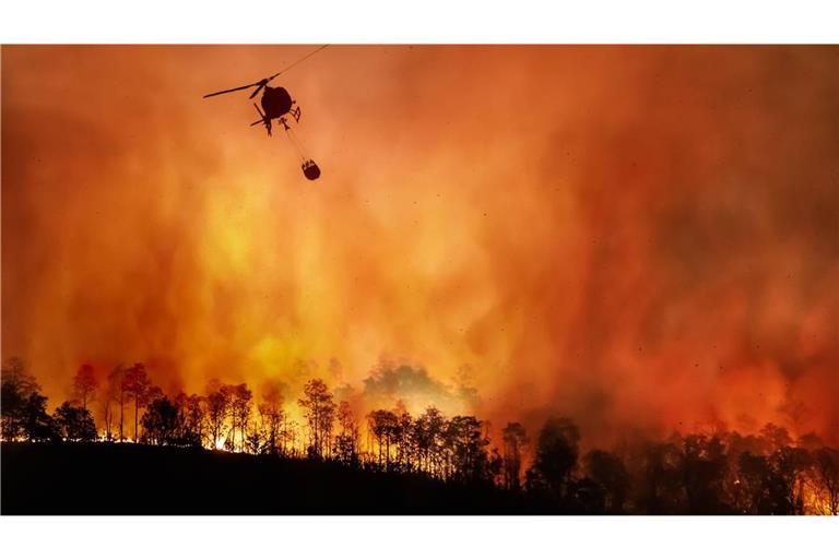 Ein Hubschrauber wirft im brasilianischen Amazonas Löschwasser ab.