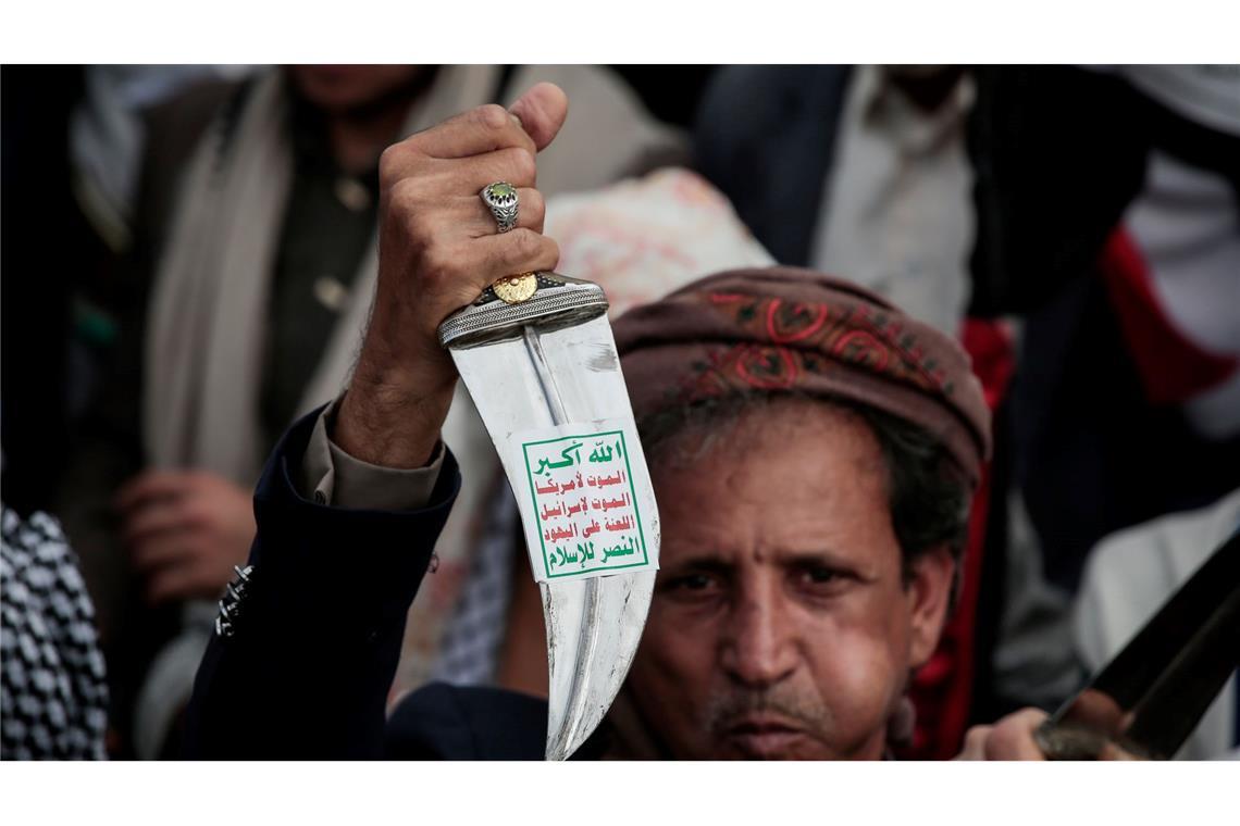 Ein Huthi-Anhänger hebt einen traditionellen jemenitischen Dolch (Jambiya) mit dem Huthi-Slogan (Sarkha), der übersetzt "Allah ist der Größte, Tod für Amerika, Tod für Israel, Fluch über die Juden, Sieg für den Islam" bedeutet, während einer Demonstration in Sanaa.