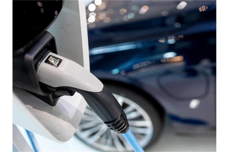 Ein Hybrid-Fahrzeug steht an einer Ladestation. Deutsche Autokunden fahren immer noch auf besonders leistungsstarke Neuwagen ab. Foto: Sven Hoppe/dpa