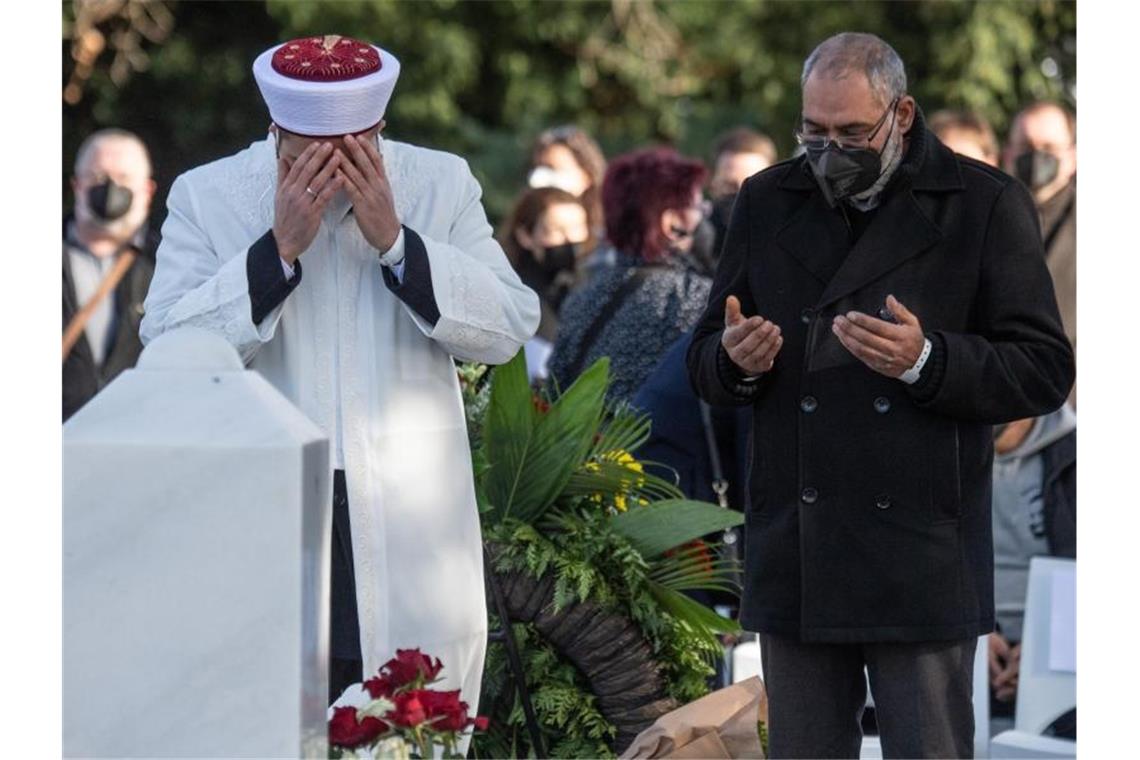 Anschlag in Hanau: „Kein Vergeben - kein Vergessen“ Ein Imam betet mit Angehörigen auf dem Friedhof von Hanau. Foto: Boris Roessler/dpa POOL/dpa