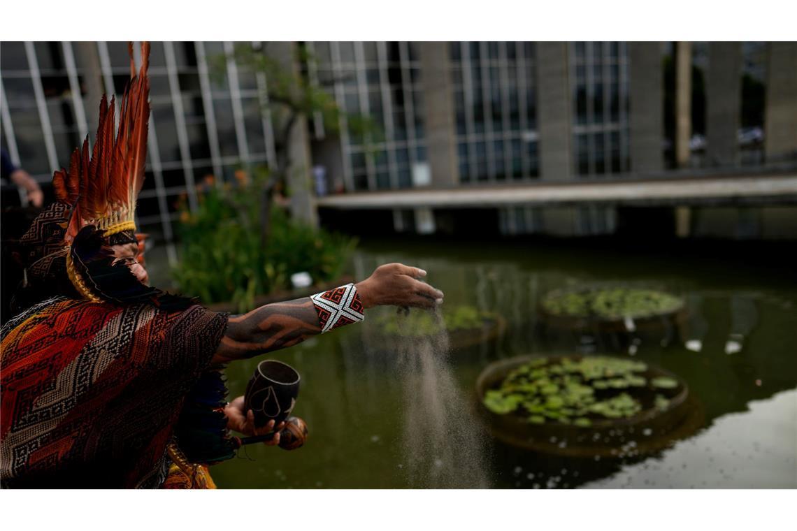 Bilder des Tages Ein indigener spiritueller Führer streut vor dem Itamaraty-Palast in Brasilia Asche von den Amazonasfeuern aus, um im Vorfeld des UN-Klimagipfels COP30 die Staats- und Regierungschefs zu einer gerechten Energiewende und zum Ausstieg aus fossilen Brennstoffen zu drängen.