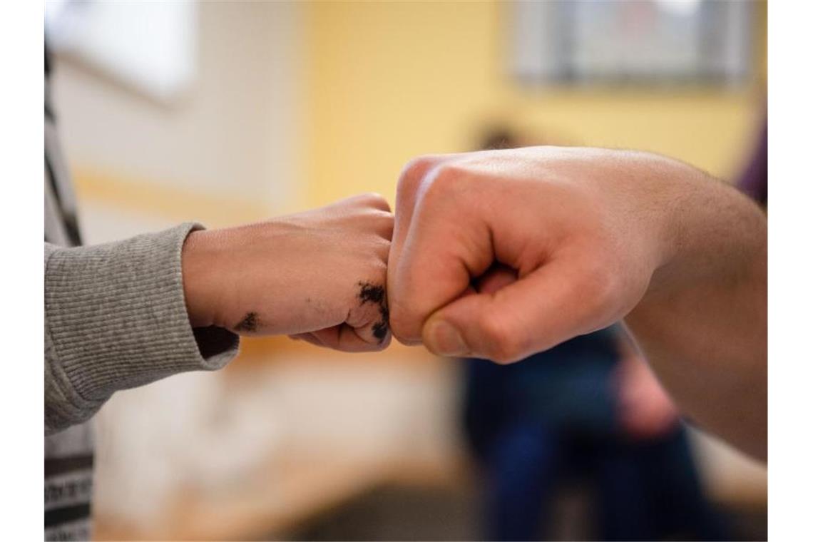 Rund 100.000 Kinder haben ein Elternteil im Gefängnis Ein Insasse gibt in der Vater-Kind-Gruppe in der JVA Nürnberg seinem Sohn einen Fist Bump. Foto: Nicolas Armer/dpa