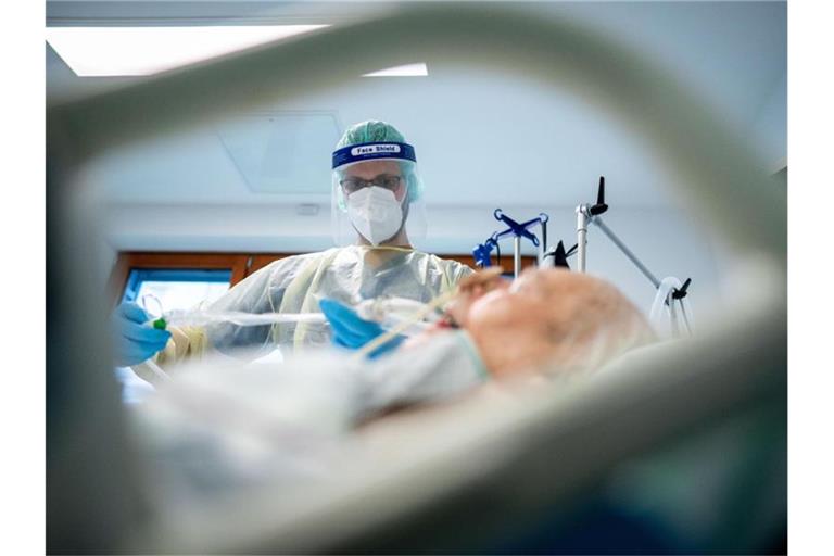Ein Intensivpfleger arbeitet in Schutzausrüstung auf der Intensivstation des Krankenhauses Bethel in Berlin an einem Corona-Patienten. Foto: Kay Nietfeld/dpa