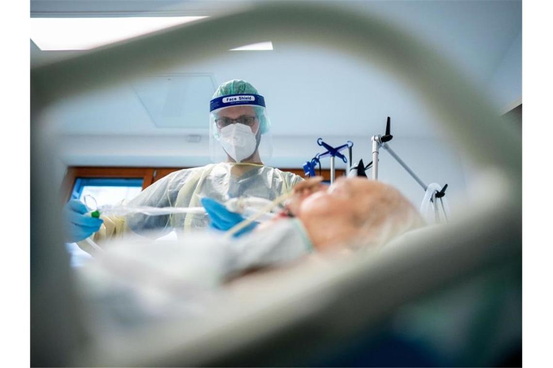 Über 75.000 Corona-Tote in Deutschland seit Pandemiebeginn Ein Intensivpfleger arbeitet in Schutzausrüstung auf einer Intensivstation. Seit Beginn der Corona-Pandemie sind in Deutschland mehr als 75.000 Menschen an oder mit dem Virus gestorben. Foto: Kay Nietfeld/dpa