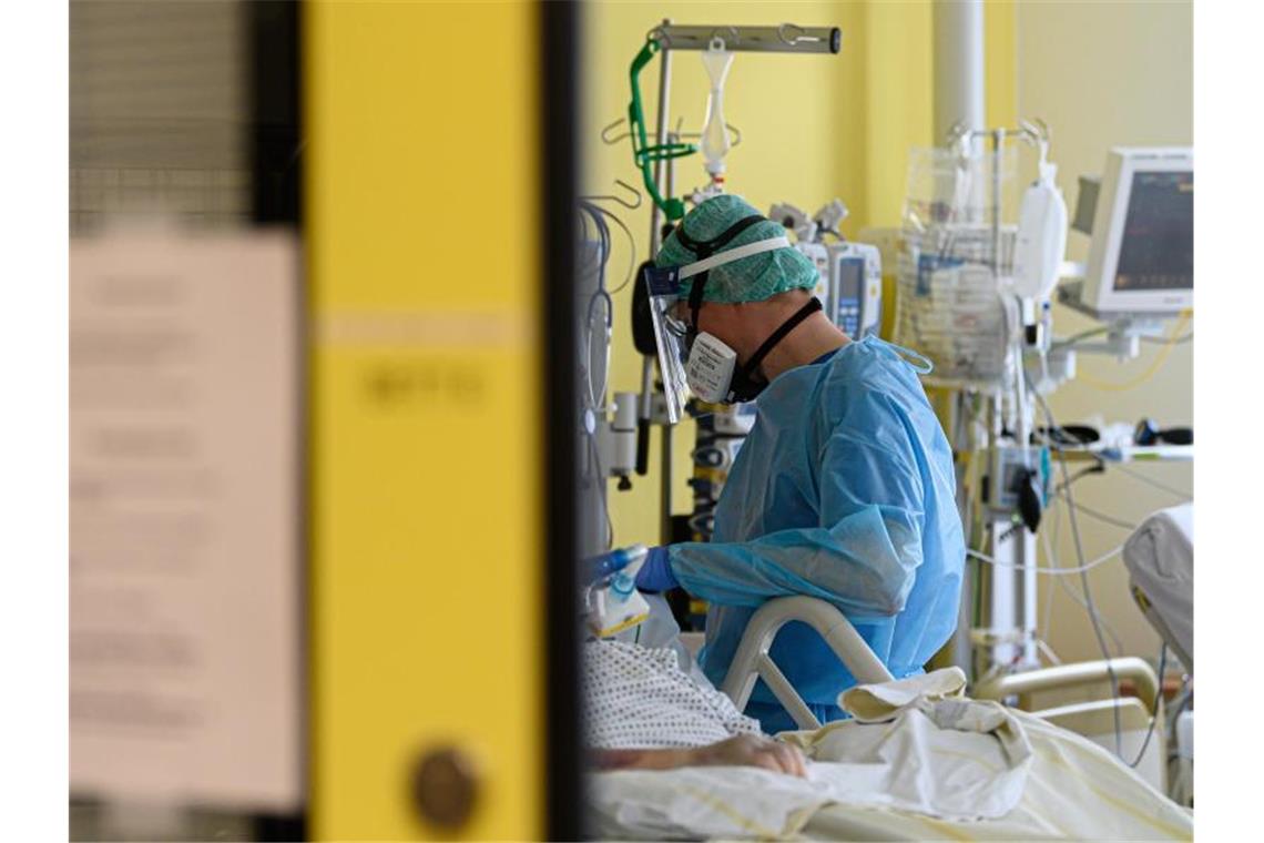 Ein Intensivpfleger ist auf der Covid-19 Intensivstation (ITS) im Städtischen Klinikum Dresden mit der Versorgung von Corona-Patienten beschäftigt. Foto: Robert Michael/dpa-Zentralbild/dpa