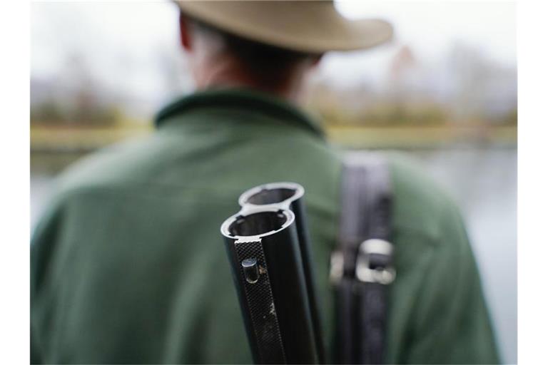 Ein Jäger steht mit seinem Gewehr in seinem Jagdrevier. Foto: Uwe Anspach/dpa/Archivbild