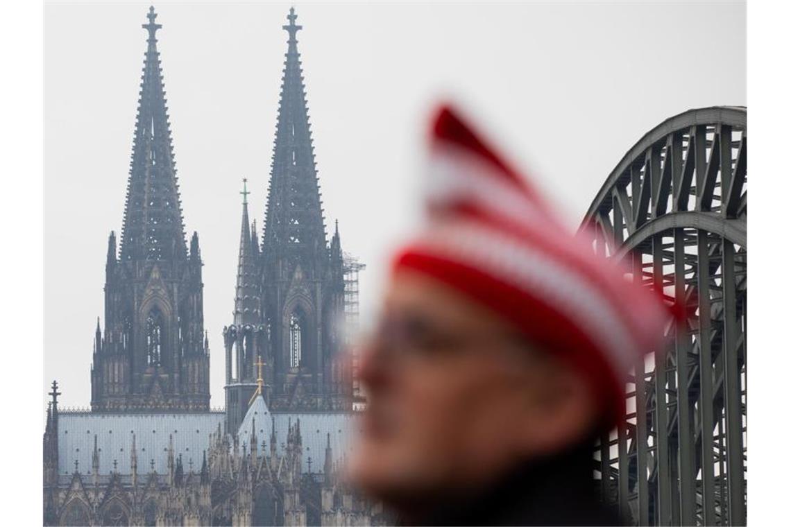 Ein Jeck steht vor dem Dom. Der 11.11. soll ein Tag wie jeder andere werden. Wegen der Corona-Pandemie ist der Auftakt der Karnevalssaison abgesagt. Foto: Rolf Vennenbernd/dpa