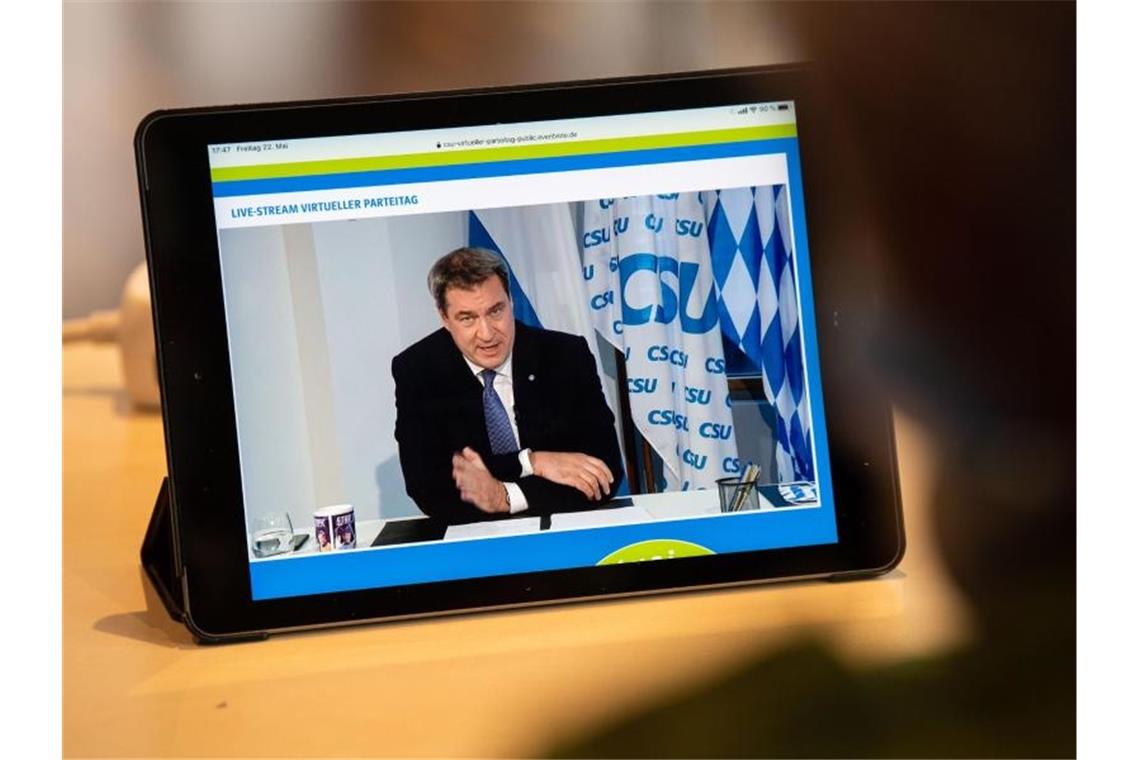 Ein Journalist beobachtet den Livestream vom CSU-Parteitag, bei dem Parteichef Markus Söder spricht. Foto: Lino Mirgeler/dpa