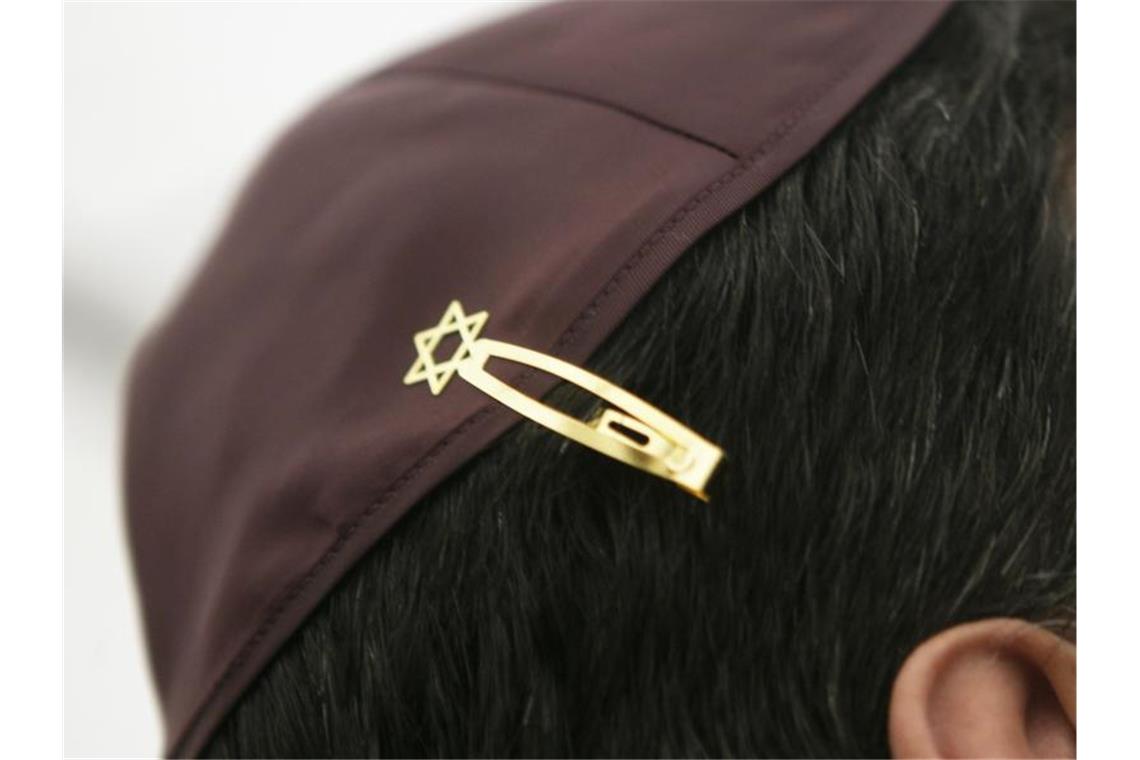 Ein Jude hat sich bei den Feierlichkeiten einer Grundsteinlegung für eine Synagoge seine Kopfbedeckung (Kippa) mit einer Davidstern-Klammer am Haar befestigt. Foto: Fredrik von Erichsen/dpa