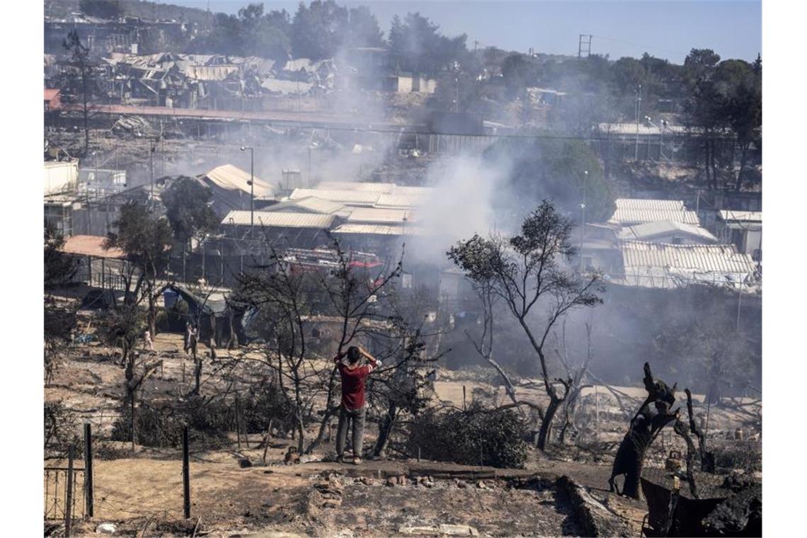 Asylreform: EU-Kommission setzt auf rigorose Abschiebungen Ein Junge blickt auf das niedergebrannte Flüchtlingslager Moria auf der griechischen Insel Lesbos. Foto: Petros Giannakouris/AP/dpa