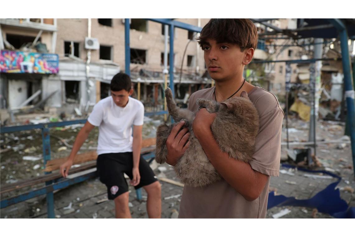 Bilder des Tages Ein Junge bringt nach einem russischen Luftangriff im ukranischen Saporischschja eine Katze in Sicherheit.