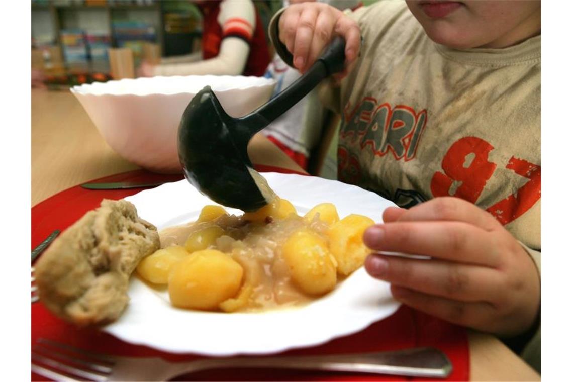 Ein Junge nimmt sich beim Mittagstisch des Kinderschutzbundes in Schwerin Soße für die Kartoffeln. Foto: Jens Büttner