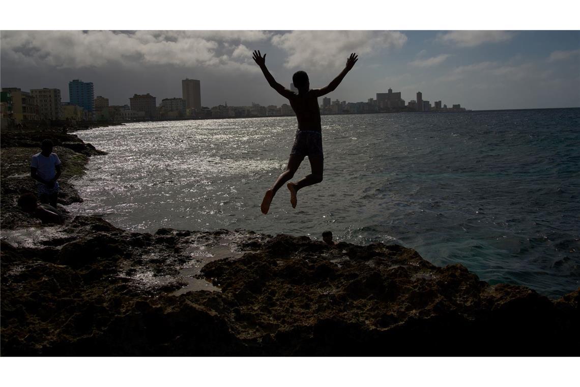 Ein Junge springt ins Meer, auch wenn der Strom in Land ausgefallen ist.