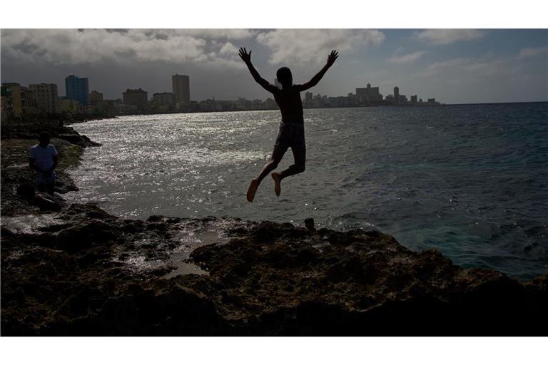 Ein Junge springt ins Meer, auch wenn der Strom in Land ausgefallen ist.