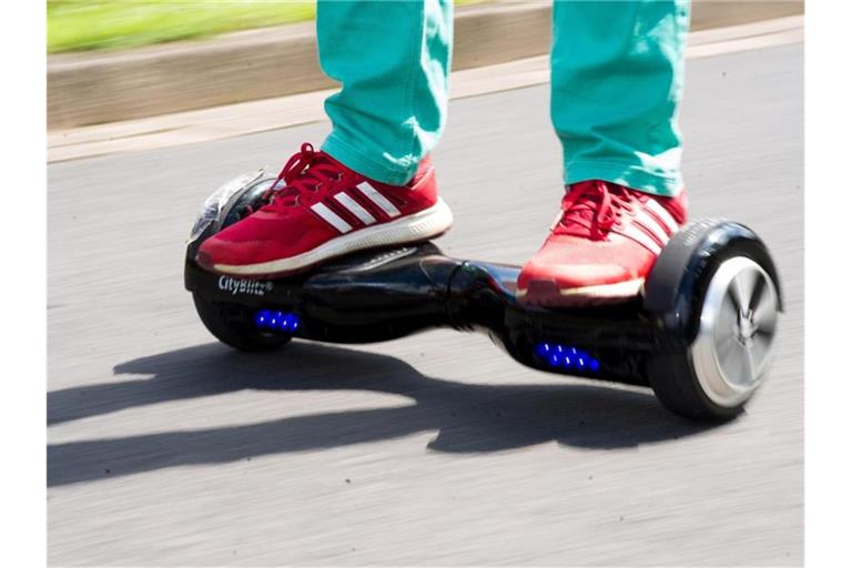 Ein junger Mann fährt mit einem Hoverboard auf einer Straße. Foto: Swen Pförtner/Archivbild