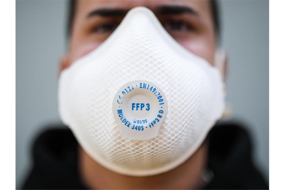 Ein junger Mann trägt eine Atemschutzmaske der Kategorie FFP3. Foto: Christoph Schmidt/dpa/Archivbild