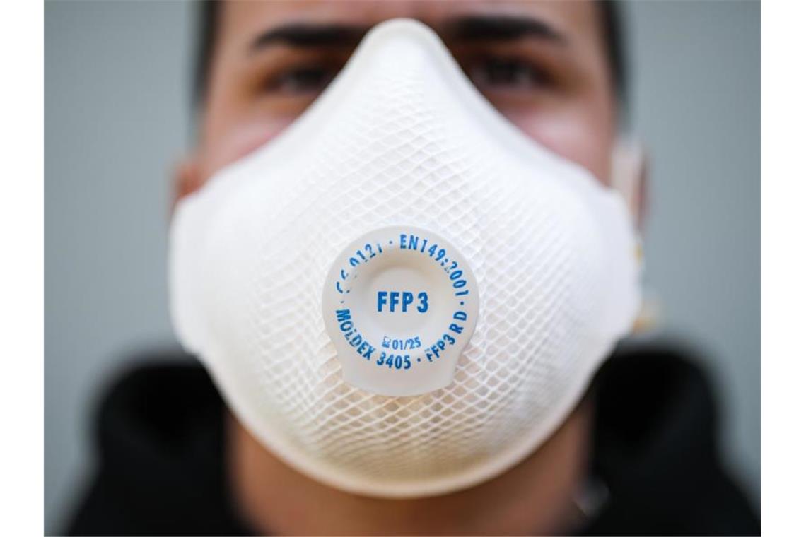 Ein junger Mann trägt eine Atemschutzmaske. Foto: Christoph Schmidt/dpa/Symbolbild