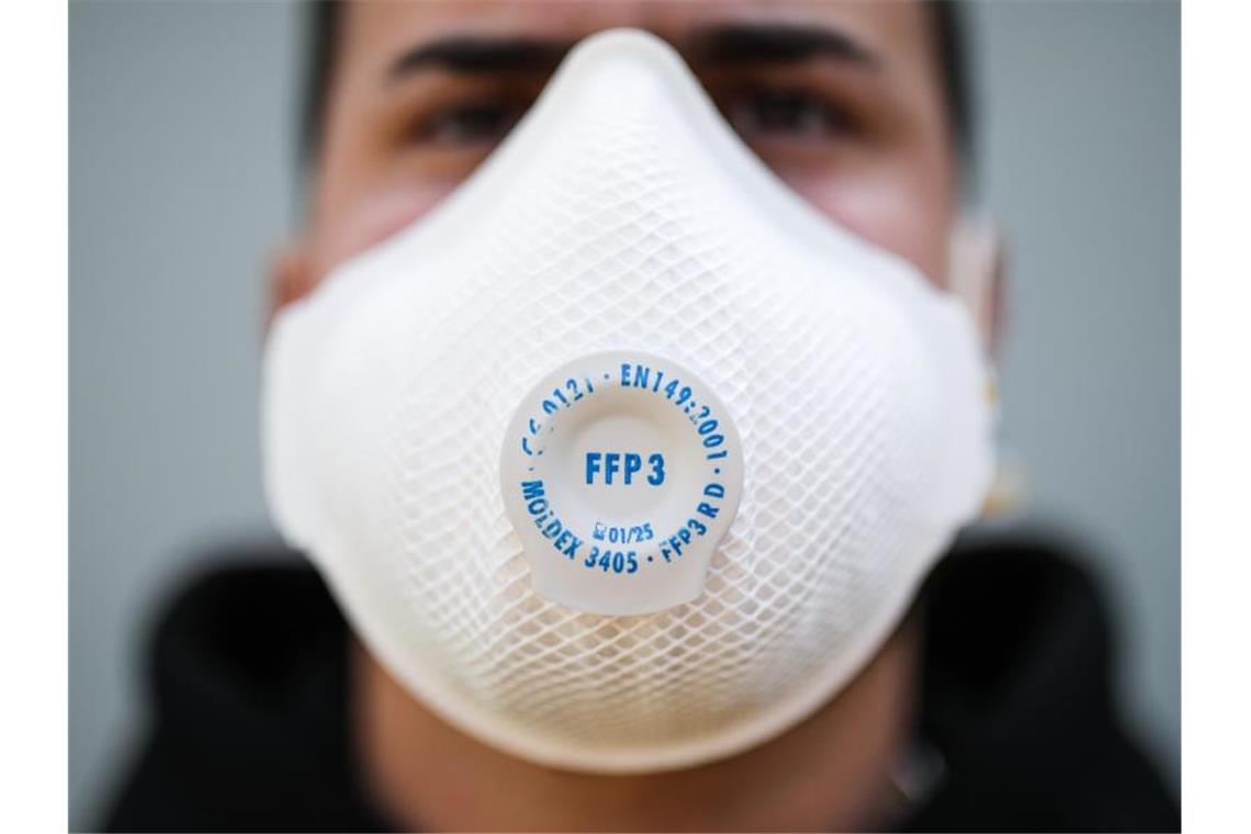 Autofahrer dürfen Schutzmasken am Steuer tragen Ein junger Mann trägt eine Atemschutzmaske. Foto: Christoph Schmidt/dpa/Symbolbild