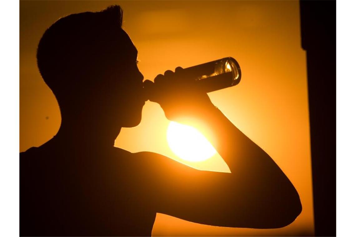 Ein junger Mann trinkt ein Bier. Foto: Julian Stratenschulte/dpa/Symbolbild