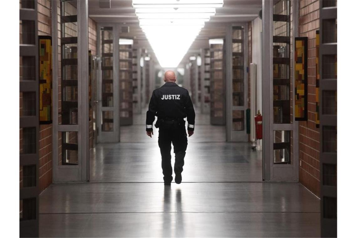 Väter nehmen im Gefängnis Hörbücher für ihre Kinder auf Ein Justizbeamter geht über einen langen Flur in einer Justizvollzugsanstalt. Foto: Julian Stratenschulte/dpa/Archiv