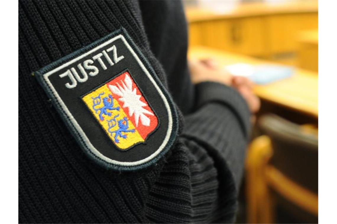 Paketzusteller rammte Radfahrer und stach mit Messer zu Ein Justizbeamter steht im Landgericht im Sitzungssaal. Foto: Angelika Warmuth/dpa/Archivbild
