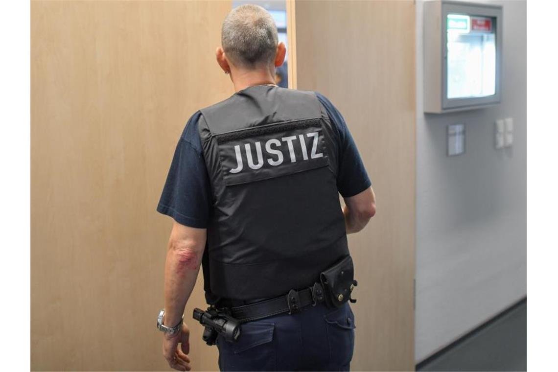 Ein Justizmitarbeiter schließt die Tür zu einem Verhandlungssaal. Foto: Patrick Pleul/zb/dpa/Symbolbild