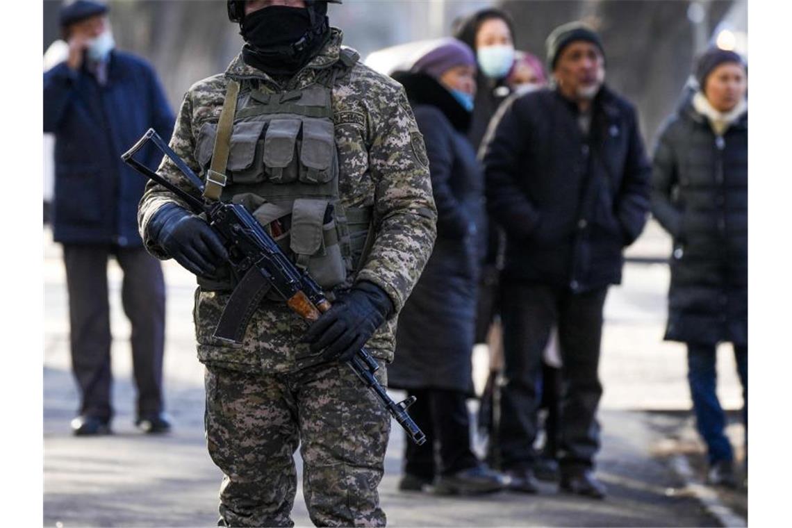 Kasachstan: Höhere Zahlen an Toten und Verletzten Ein kasachischer Soldat patrouilliert in Almaty nahe einer Polizeistation. Hinter ihm versammeln sich Angehörige von Personen, die nach den Protesten gegen die Regierung verhaftet wurden. Foto: Sergei Grits/AP/dpa