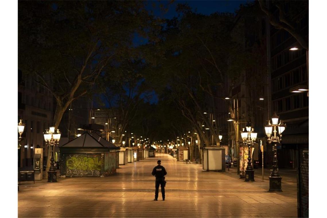 Spanien meldet niedrigste Totenzahl seit dem 24. März Ein katalanischer Polizist mitten auf der Straße La Rambla in Barcelona. In Spanien gilt eine landesweite Ausgangssperre. Foto: Felipe Dana/AP/dpa
