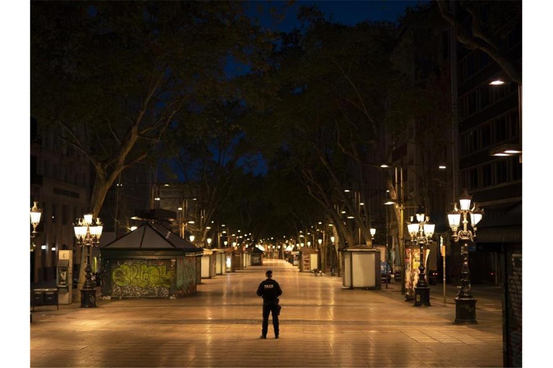 Ein katalanischer Polizist mitten auf der Straße La Rambla in Barcelona. In Spanien gilt eine landesweite Ausgangssperre. Foto: Felipe Dana/AP/dpa