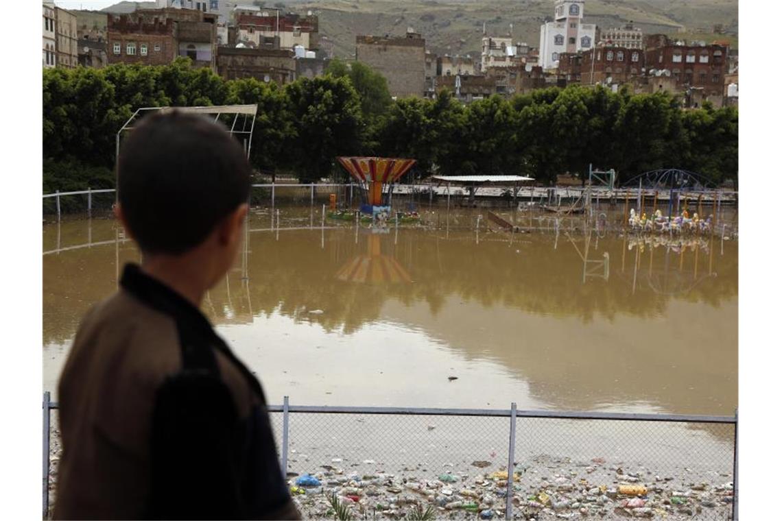 Regen und Übeschwemmungen im Jemen: Mehr als 130 Tote Ein Kind blickt auf einen überschwemmten Vergnügungspark in Sanaa. Foto: Mohammed Mohammed/XinHua/dpa