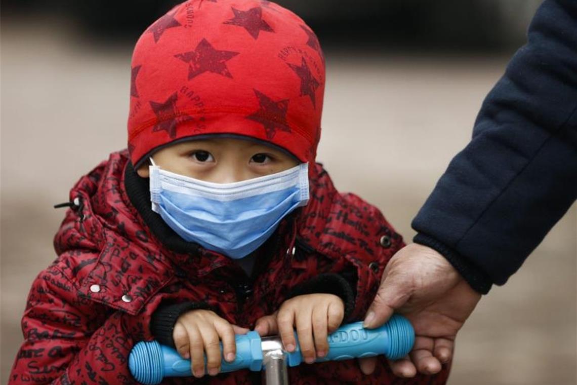 Ein Kind in Peking trägt zum Schutz vor Smog eine Atemmaske. Foto: Rolex Dela Pena/EPA/dpa