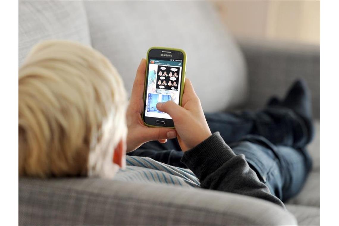 Ein Kind mit einem Smartphone. Wann ist der beste Zeitpunkt für das erste Gerät?. Foto: Tobias Hase/dpa