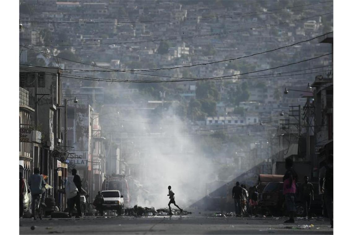 Mindestens ein Journalist bei Protest in Haiti erschossen Ein Kind rennt über eine Straße in der Innenstadt von Port-au-Prince. (Archivbild). Foto: Matias Delacroix/AP/dpa