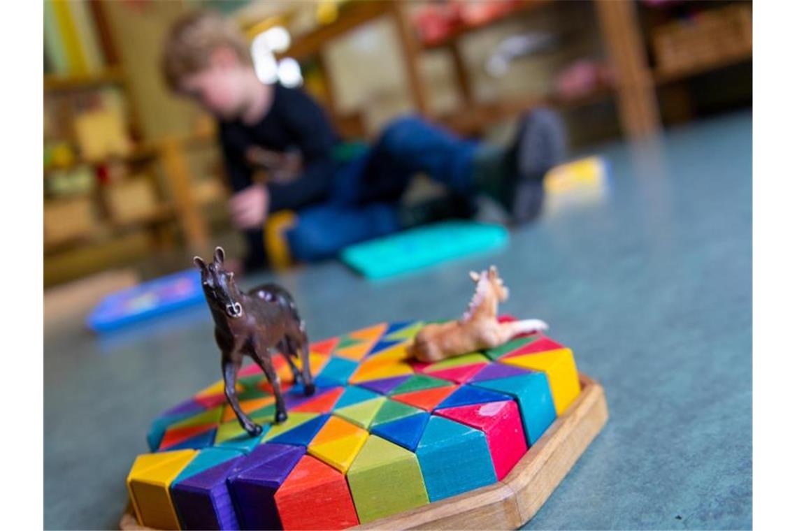 Ein Kind spielt in einem Kindergarten auf dem Boden. Foto: Monika Skolimowska/dpa-Zentralbild/dpa/Symbolbild