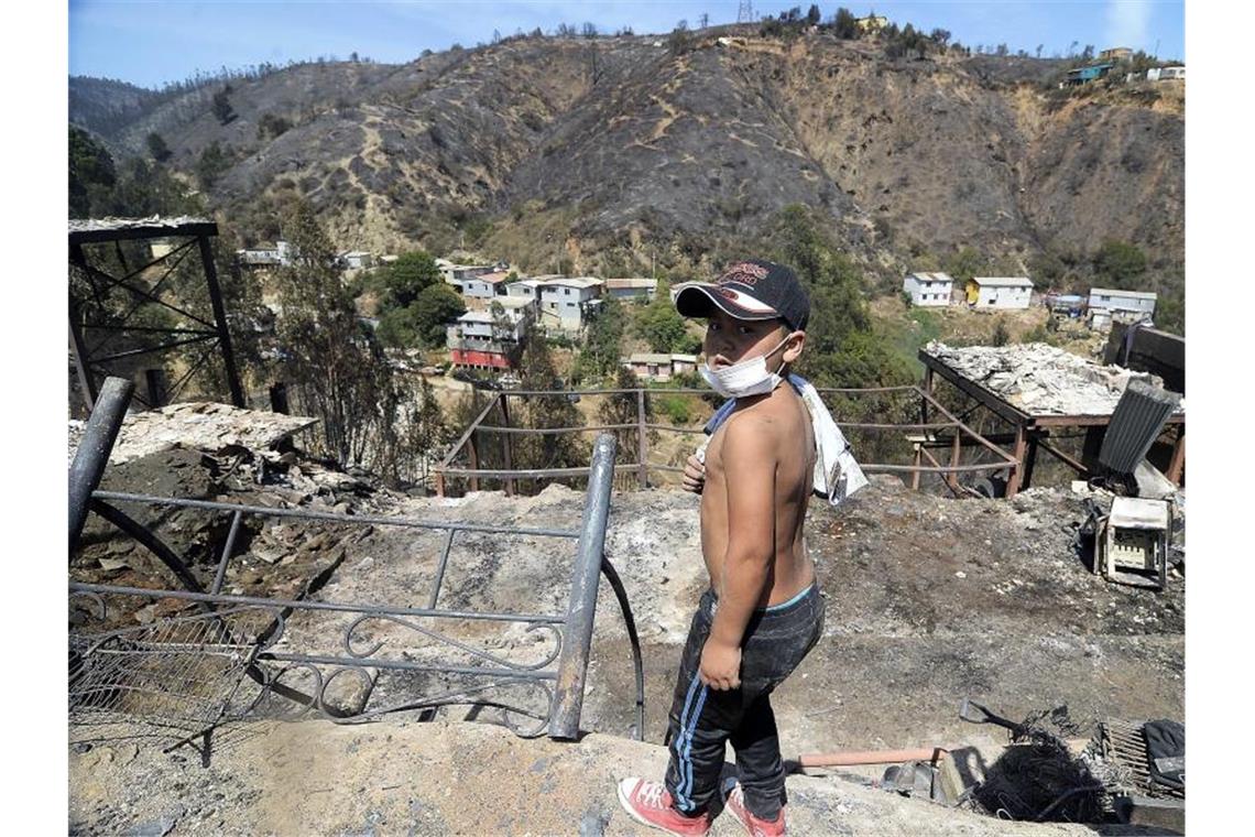 Ein Kind steht vor einem vom Feuer betroffenen Hügel in Valparaiso. Foto: Pablo Ovalle Isasmendi/Agencia Uno/dpa