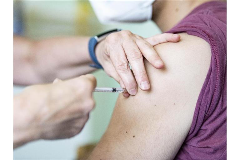 Ein Kinder- und Jugendarzt impft einen Jugendlichen mit dem Corona-Impfstoff Comirnaty von Biontech/Pfizer. Es mehren sich die Forderungen an die Ständige Impfkommission (Stiko), ihre Haltung zur Corona-Impfung von Jugendlichen zu überdenken. Foto: Fabian Sommer/dpa