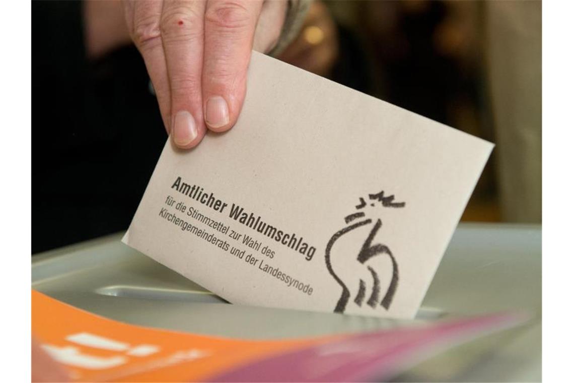 Ein Kirchenmitglied gibt am 01.12.2013 seinen Wahlzettel bei der Kirchenwahl in Baden-Württemberg ab. Foto: Marijan Murat/dpa/Archivbild