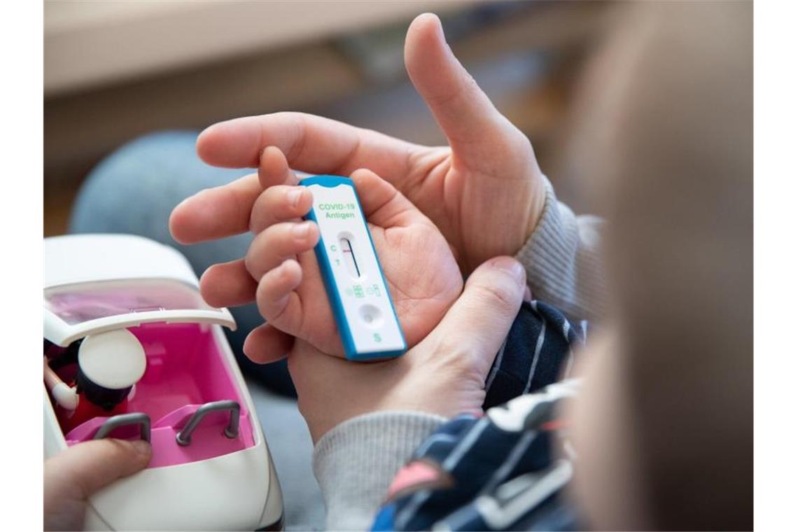 RKI: Teils sehr hohe Inzidenzen bei Kindern und Jugendlichen Ein Kita-Kind und seine Mutter warten daheim auf das Ergebnis eines Corona-Selbsttests. Foto: Friso Gentsch/dpa